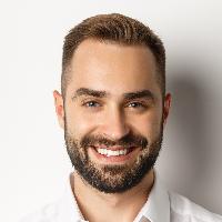 Close Up Of Confident Male Employee In White Collar Shirt Smiling At Camera, Standing Self Assured Against Studio Background