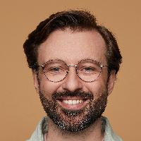 Studio Portrait Of Bearded Man Posing Over Beige Background Looking Into Camera With Broad Smile On His Face